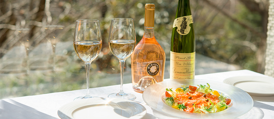 Appetizer and wine on a bright table facing greenery at Hibiya Matsumotoro