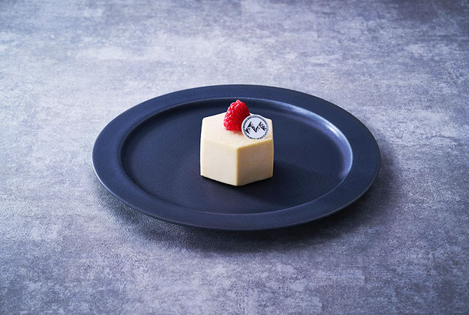 White cube-shaped petit gâteau with raspberry by Mont St. Clair