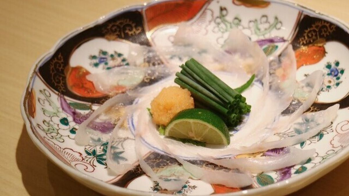 Translucent sashimi arranged on an antique patterned plate at Kiyosumi Takahara