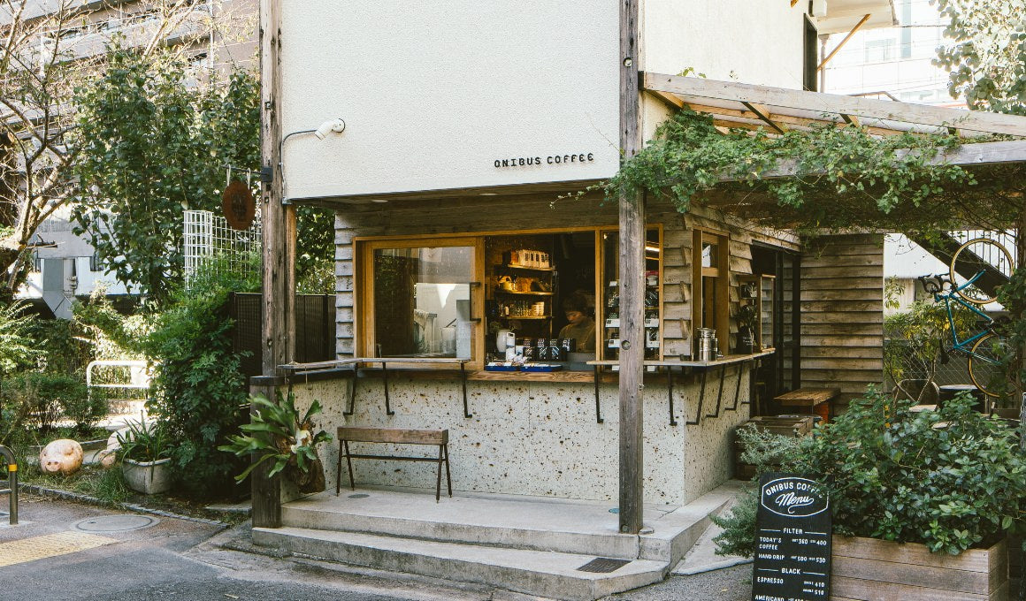 Small timber and stone ONIBUS COFFEE shop surrounded by greenery in Nakameguro