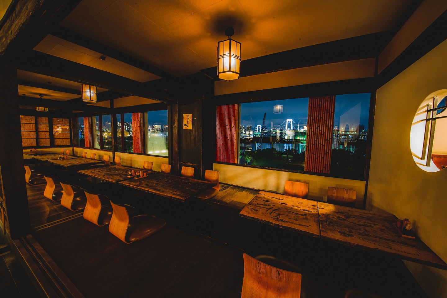 Japanese-style dining room at Gonpachi Odaiba overlooking Rainbow Bridge at night