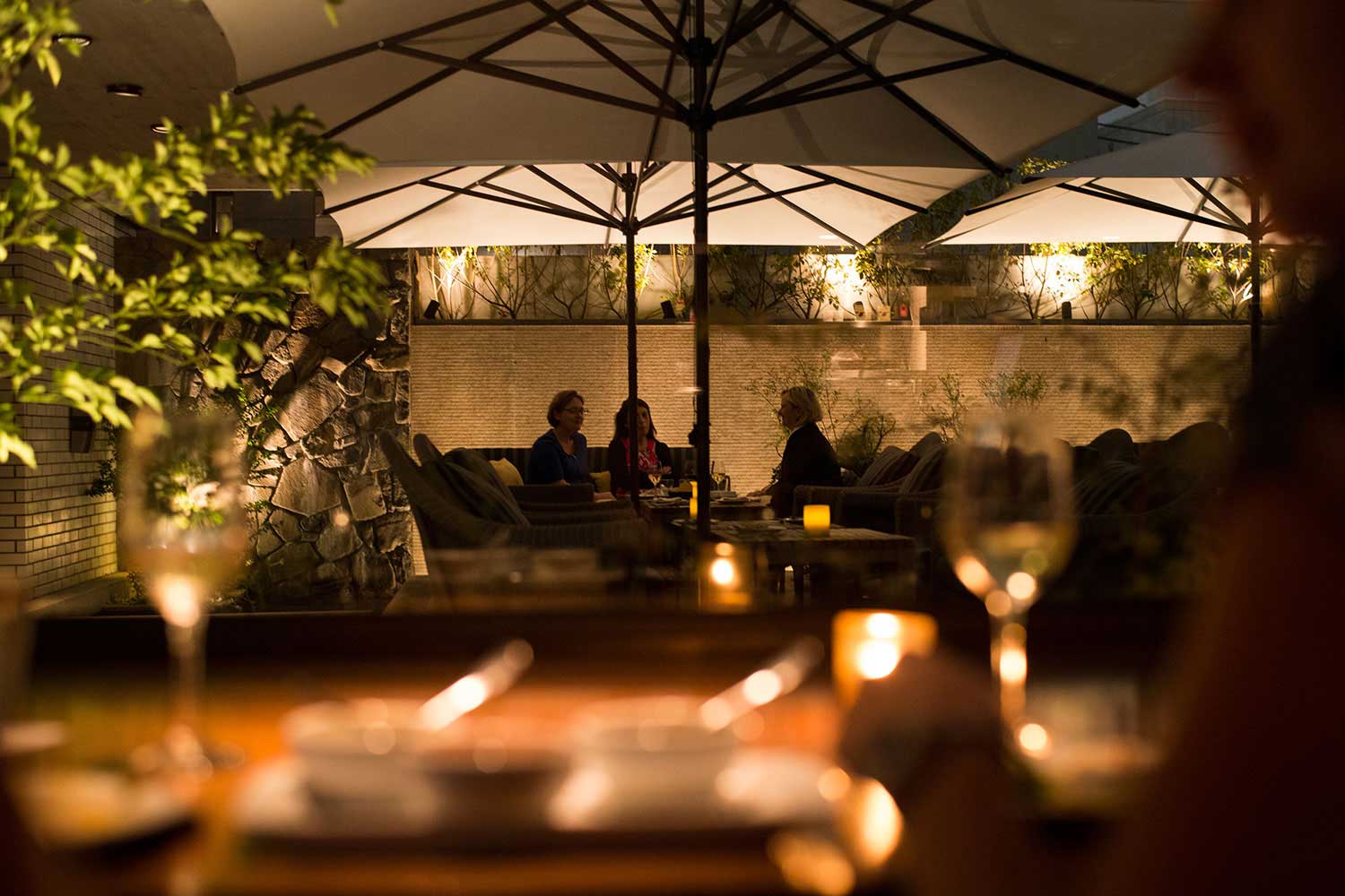 Candlelit terrace surrounded by greenery at CICADA in Omotesando