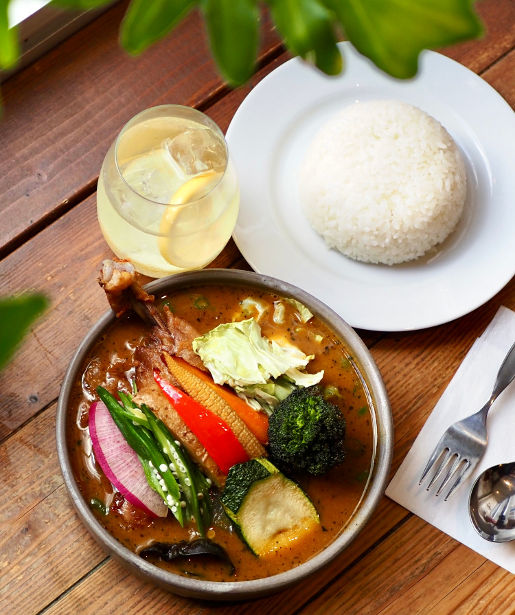 Ponipirica soup curry with chicken and colorful vegetables beside rice