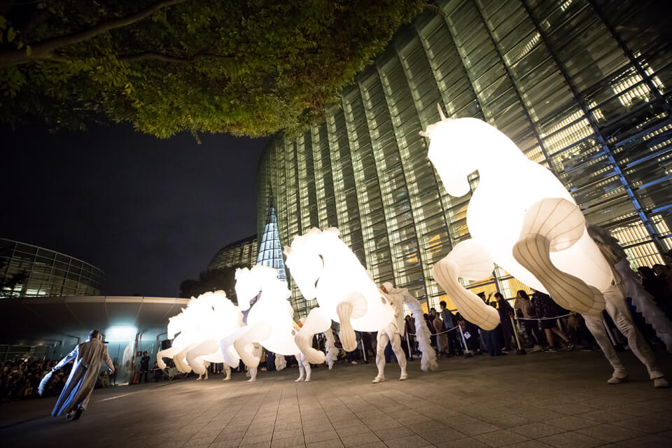 Illuminated performers moving through a past Roppongi Art Night